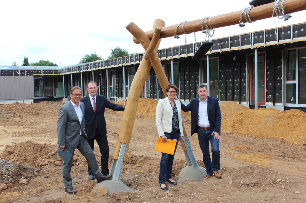 Bürgermeister Reiner Breuer, Baudezernent Christoph Hölters, Andre Schiefke, Betriebsleiterin des Gebäudemanagements Neuss (GMN), und Harald Härtel, Leiter Planung und Neubau im GMN, auf der Baustelle der Kita „Am Mühlenbusch“.