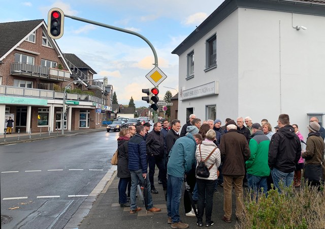stadt-neuss_ortsmittelpunkte_stadtteilspaziergang-rosellerheide-2019-10-09.jpg Eine größere Gruppe Menschen versammelt sich an einer Kreuzung.