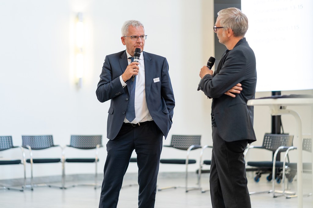neusser-zukunftskongress-2022_13b.jpg Zwei Konferenz-Teilnehmer tauschen sich auf der Bühne des Zeughauses aus.